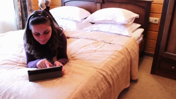 Gelukkige vrouw met de Tablet PC op het bed. — Stockvideo