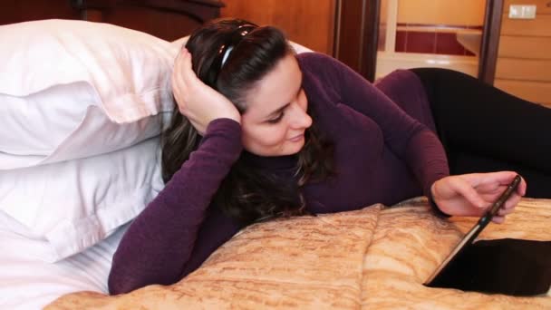 Mujer feliz con la tableta en la cama . — Vídeos de Stock