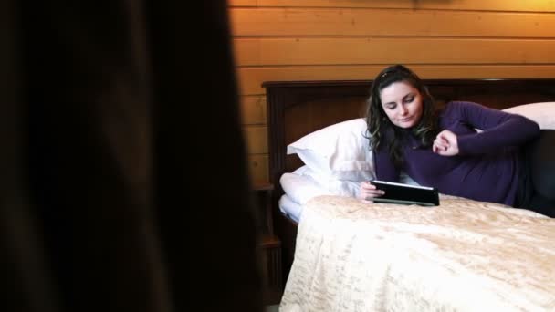 Glückliche Frau mit der Tablette auf dem Bett. — Stockvideo