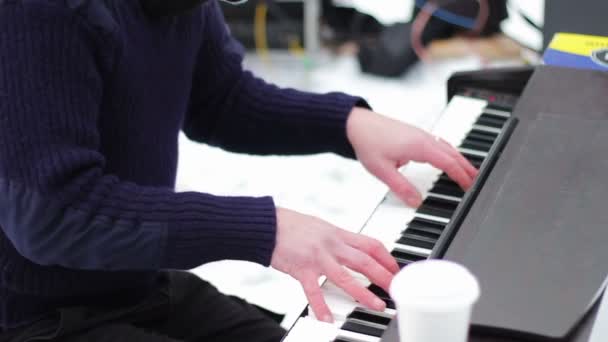 Pianista v masce hraje na klavír na ulici v zimě. — Stock video