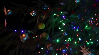 Işıklar, geceleri oyuncaklarla süslenmiş Noel ağacı.