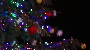 Işıklar, geceleri oyuncaklarla süslenmiş Noel ağacı.