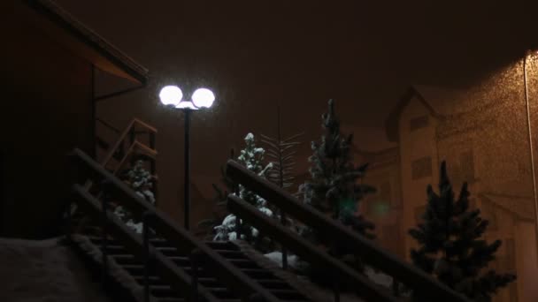 Nieva por la noche en el fondo de un poste de luz . — Vídeo de stock