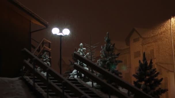 Nieva por la noche en el fondo de un poste de luz . — Vídeos de Stock