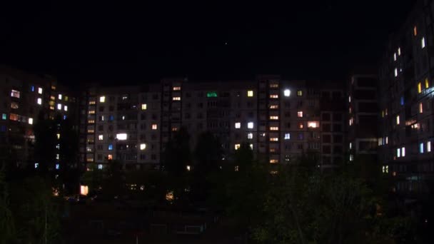 Zeitraffer eines mehrstöckigen Gebäudes mit nachts wechselnder Fensterbeleuchtung. — Stockvideo