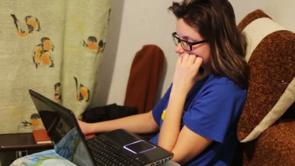 Chica estudiante cansada trabajando en una computadora portátil en casa . — Vídeo de stock