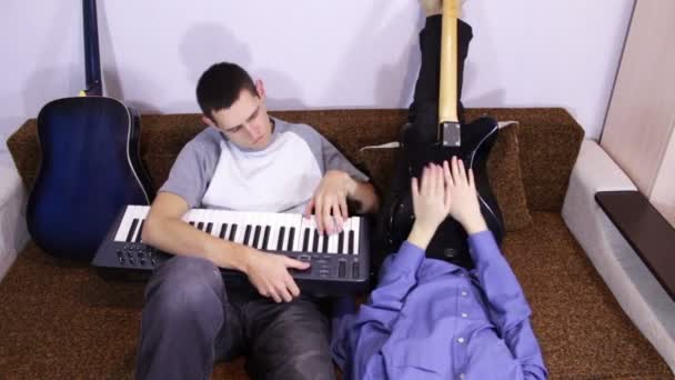 Kreatives glückliches Paar spielt Gitarre und Keyboards — Stockvideo
