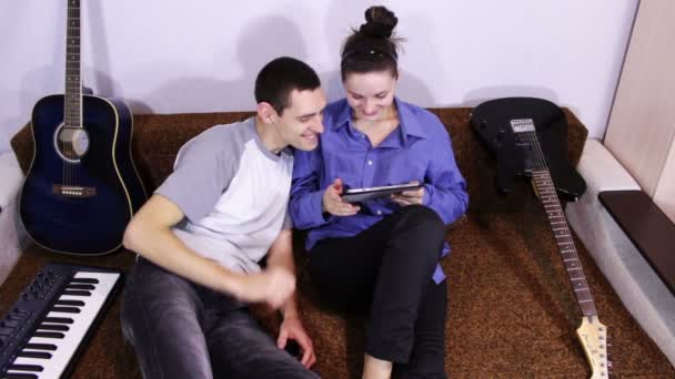 Heureux jeune couple en utilisant Tablette PC sur le canapé — Video