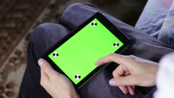 Man met Tablet PC op de Bank met groen scherm — Stockvideo