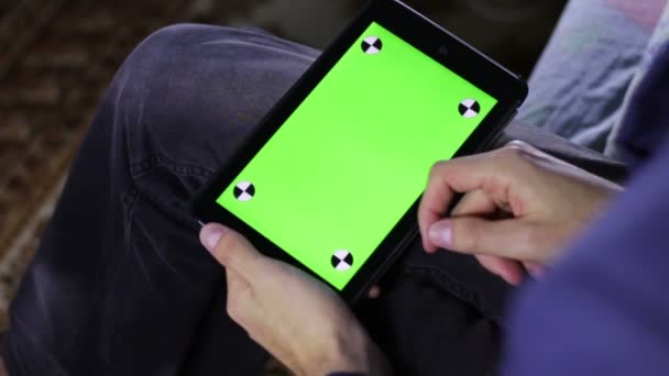 Man met Tablet PC op de Bank met groen scherm — Stockvideo