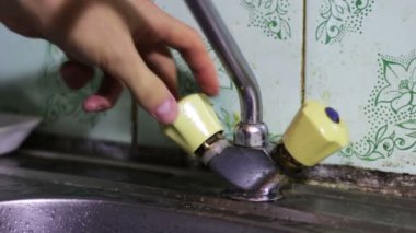 Mano cierra el agua muchos grifos en el baño para evitar el desperdicio