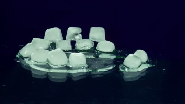 Cubo de gelo derretendo e se movendo em uma superfície de vidro — Vídeo de Stock