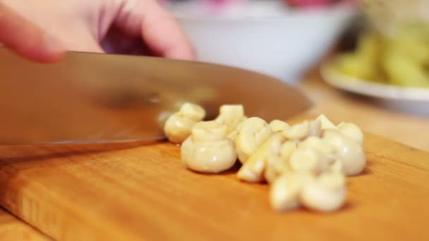 Vrouw schijfjes champignons in de keuken — Stockvideo