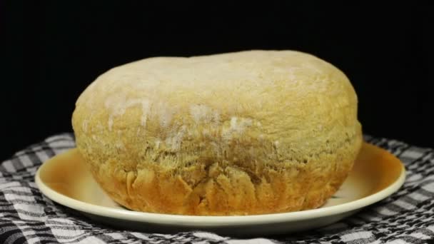 Pão caseiro na mesa gira em um fundo preto — Vídeo de Stock