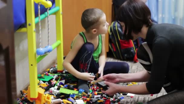 Дитина хлопчик і його матері ігрового з іграшками — стокове відео
