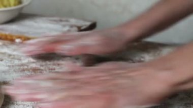 Bir kadın merdaneyle Hamuru Yuvarlıyor