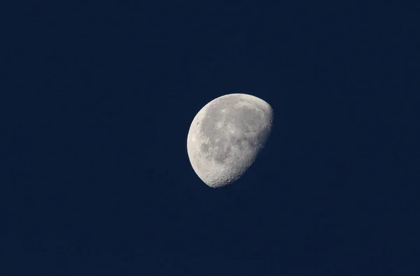 A phase of the moon against a blue sky in the UK.