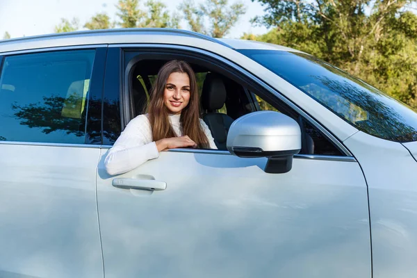 Szczęśliwa Dziewczyna Wygląda Przez Okno Białego Samochodu Uśmiecha Się — Zdjęcie stockowe
