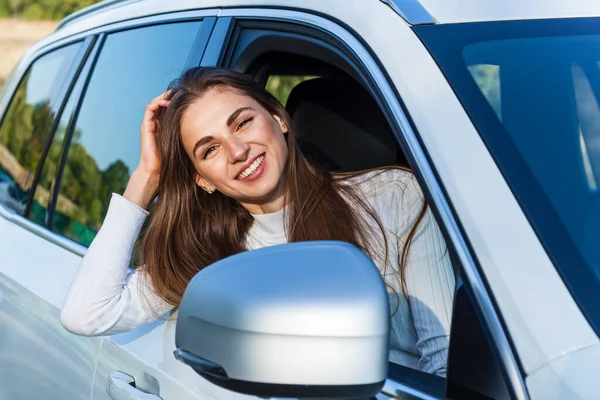 Szczęśliwa Dziewczyna Wygląda Przez Okno Białego Samochodu Uśmiecha Się — Zdjęcie stockowe
