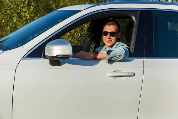 Facet Dżinsowej Kurtce Czarnych Okularach Uśmiecha Się Kierownicą Samochodu — Zdjęcie stockowe