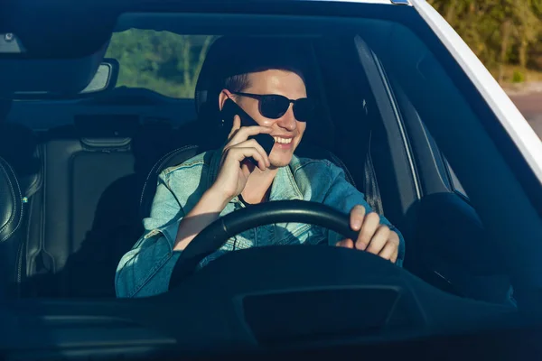 Facet Dżinsowej Kurtce Czarnych Okularach Rozmawiający Przez Telefon Podczas Jazdy — Zdjęcie stockowe