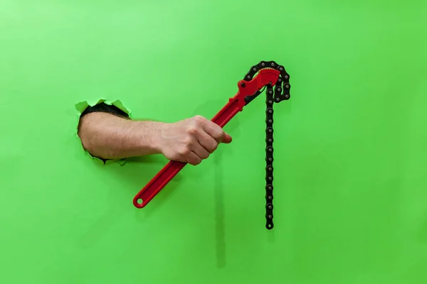 Man Handen Håller Röd Pipa Nyckel Genom Sönderriven Grön Papper — Stockfoto