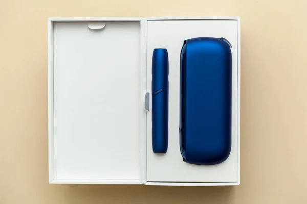 电子蓝色Iqos香烟在一个米色背景的白色盒子中 图片与地方为您的文字 标志和设计 概念办公室 — 图库照片