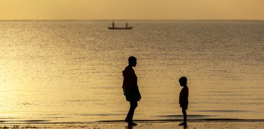 Mom and daughter in the morning on the beach
