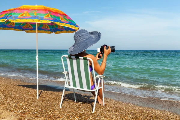 Menina na praia, banhos de sol, menina com um laptop, mulher sob um — Fotografia de Stock