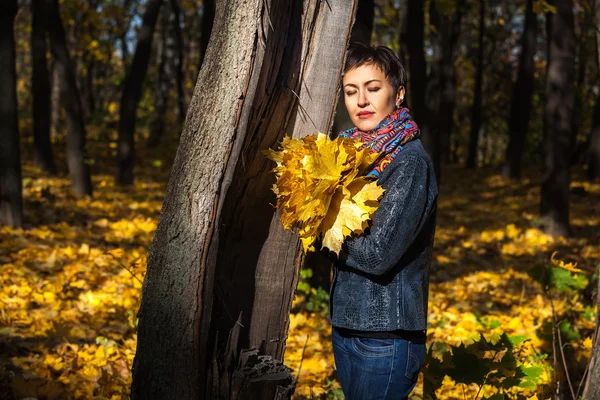 Дівчина з букетом жовтого листя в парку, букет з у — стокове фото