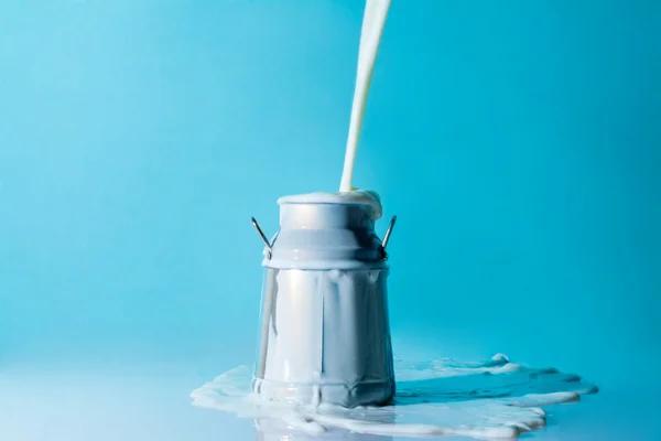 Брызги молока, струя молока льется в банку молока — стоковое фото