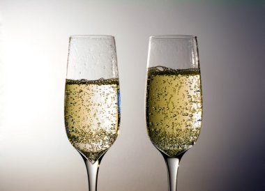 İki kadeh şampanya şarabı, kabarcıklar, gri bir arka plan üzerinde