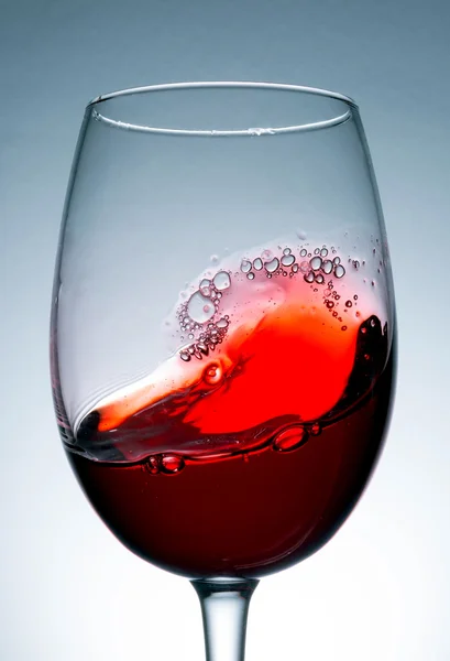 Vino in primo piano di vetro, macro, ondata di vino, spruzzi, spruzzi, bolle, consistenza — Foto Stock