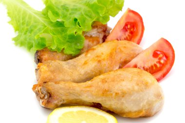 Domates dilimleri ile Tavuk bacakları, taze marul ve limon izole