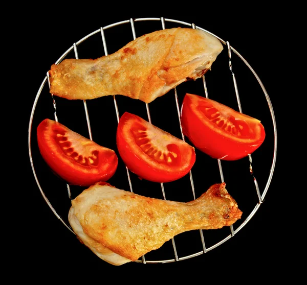Patas de pollo en la parrilla con rodajas de tomates —  Fotos de Stock