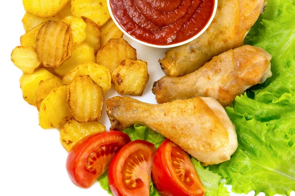 Patas de pollo frito en un plato blanco con rodajas de tomate y lechuga y papas fritas y salsa de tomate vista superior aislado —  Fotos de Stock