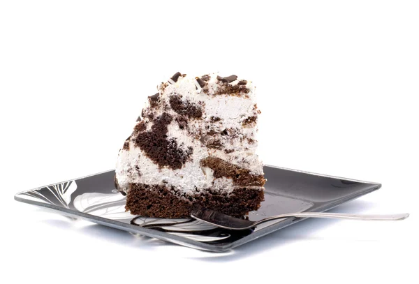 Stück Kuchen auf einem Teller mit einem Löffel auf weißem Hintergrund — Stockfoto