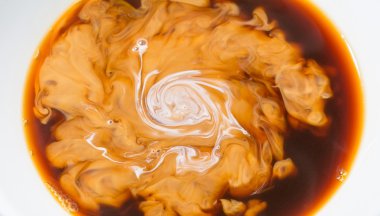 Kahve bir bardak süt, krema yakın çekim makro güzel desen damla ile