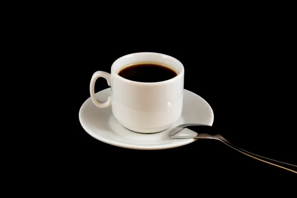 Taza de café con una cuchara aislada sobre un fondo negro — Foto de Stock