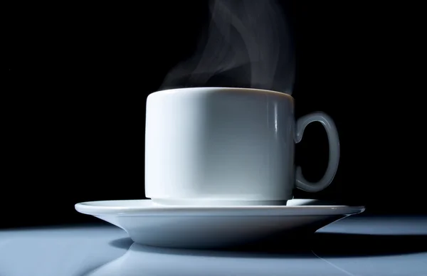 Taza de café con un hermoso humo de cerca sobre un fondo negro — Foto de Stock