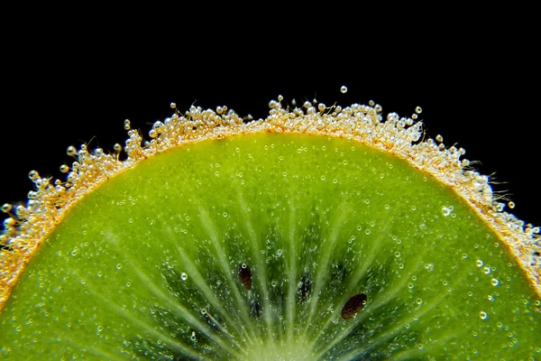 Kiwi sliced in underwater with bubbles on black background texture close-up macro — Stock Photo, Image