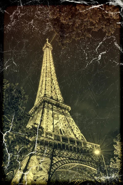 PARIS - MAY 27, 2015: Eiffel Tower brightly illuminated at dusk in Paris. Old, retro style. — Stock Photo, Image