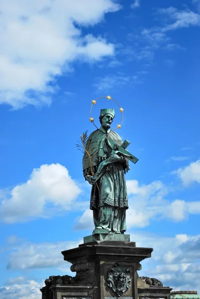 Statue des Johannes von Nepomuk in Prag auf der Karlsbrücke vor blauem Himmel — Stockfoto
