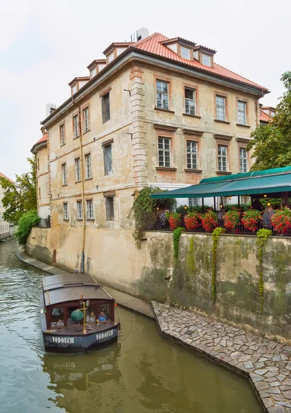 Prague, Czech Republic - 17 August, 2015: Boat on the canal in Prague on a day near the house and a cafe on the waterfront. — Stock Photo, Image