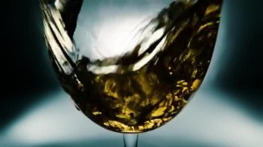 Bir bardağa dökülen beyaz şarabın yaratıcı makro yavaş çekim videosu. Doldurulmuş beyaz şaraplı bardaklar. Su ve kabarcıklarla yakın plan..