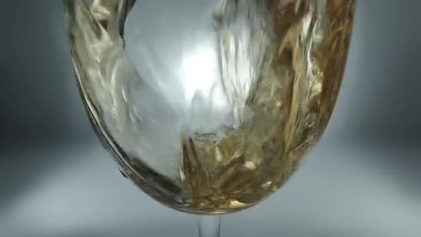 ガラスに注ぐ白ワインの創造的なマクロスローモーション生ビデオ スプラッシュと泡で白ワインのクローズアップを注ぐガラス — ストック動画