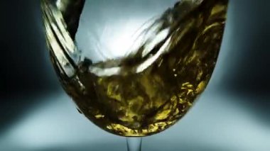 Bir bardağa dökülen beyaz şarabın yaratıcı makro yavaş çekim videosu. Doldurulmuş beyaz şaraplı bardaklar. Su ve kabarcıklarla yakın plan..