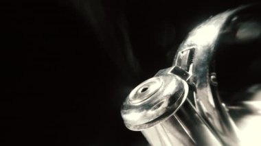 4k makro ham video çaydanlık ıslık, kaynayan su ısıtıcısı siyah arka planda buhar dokusu.