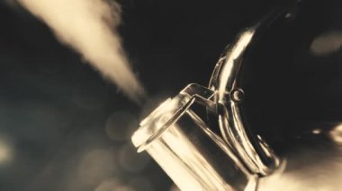 Su ısıtıcısının ıslık çaldığı 4k makro video, güzel bir bokeh siyah arka planda buhar desenli kaynar su ısıtıcısı. Antika, grunge eski usul video.