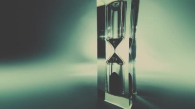 Modern kum saatinin hızlandırılmış makro videosu. Kum saati yakın plan. Kum dokusu, düşen kum. Eski grunge vintage tarzı.